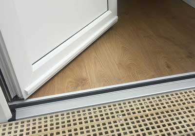 Worn-out door threshold showing signs of damage and wear