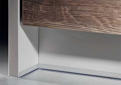 Close-up of PVC plinth sealing strip installed neatly under kitchen cabinets